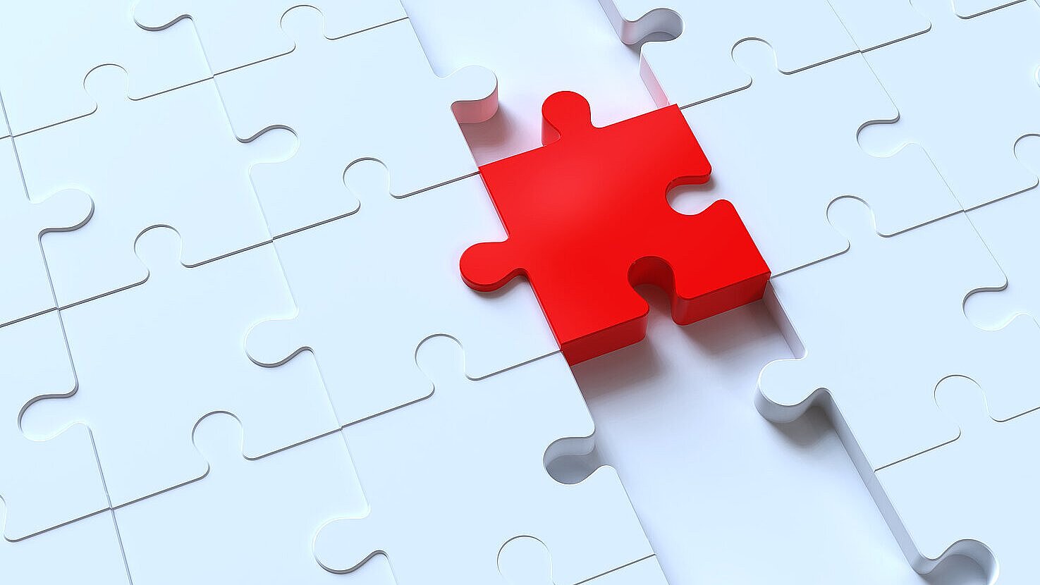 2185984918 Nahaufnahme eines weißen Puzzlefeldes mit einer einzelnen roten Puzzleteil, das deutlich hervorsticht und fast vollständig in die vorgesehene Lücke eingefügt ist.